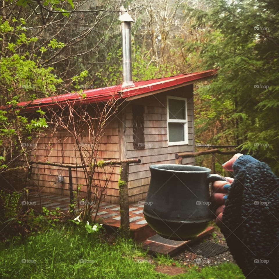 Close-up of a woman holding cup in front of house