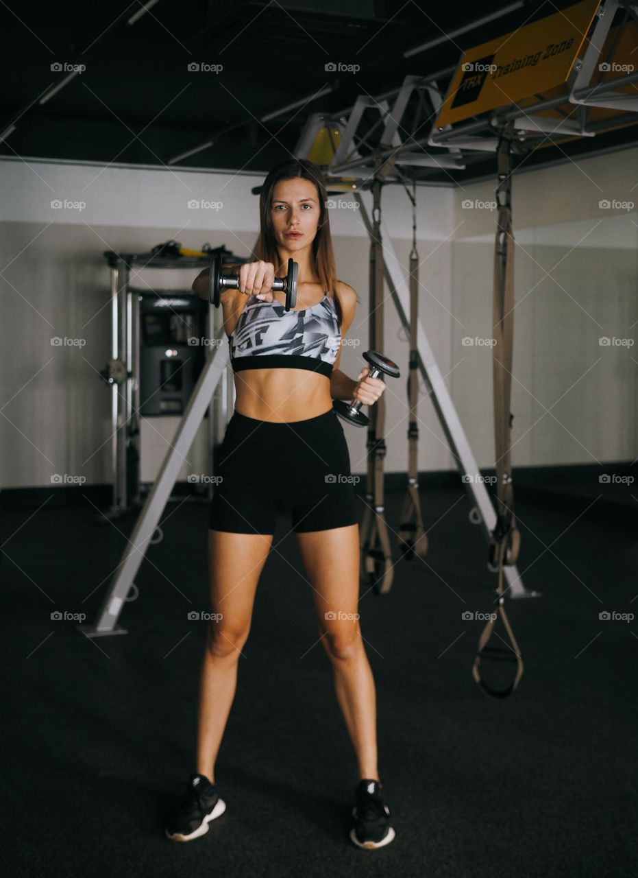 Young beautiful brunette woman in gym 
