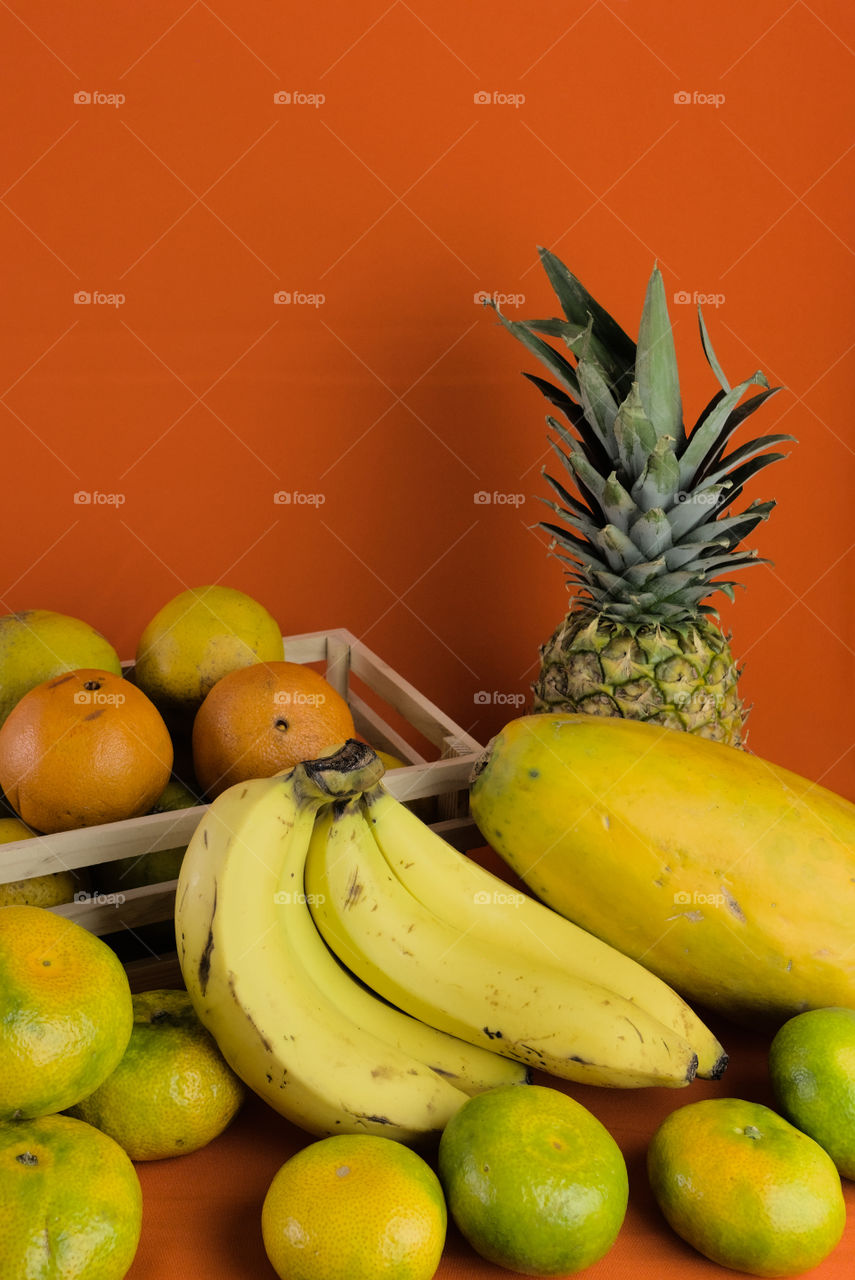 Natural fruits for preparation of fruit juice on orange background