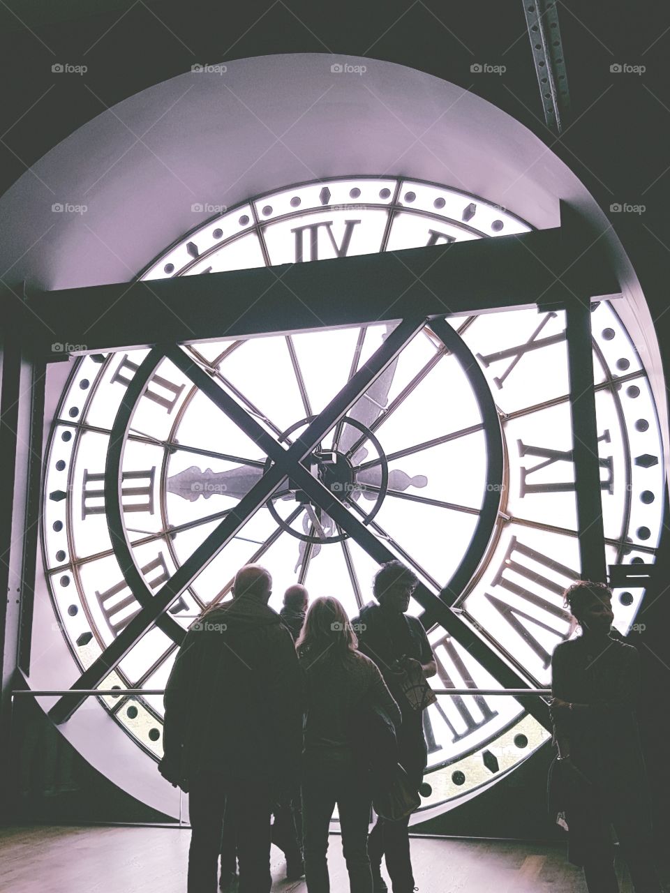A time of gathering. A group of people look through the clock window