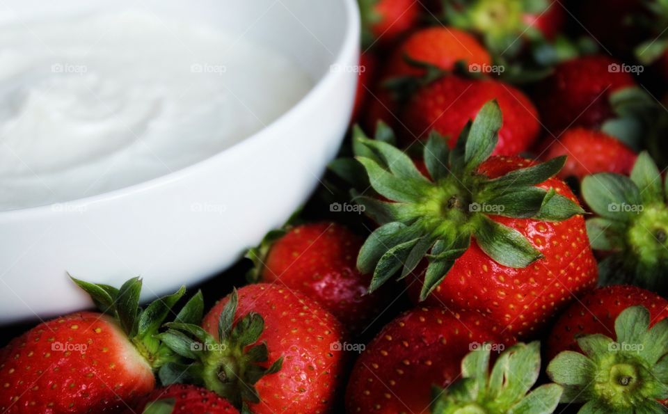 bowl of yogurt and tray of strawberries