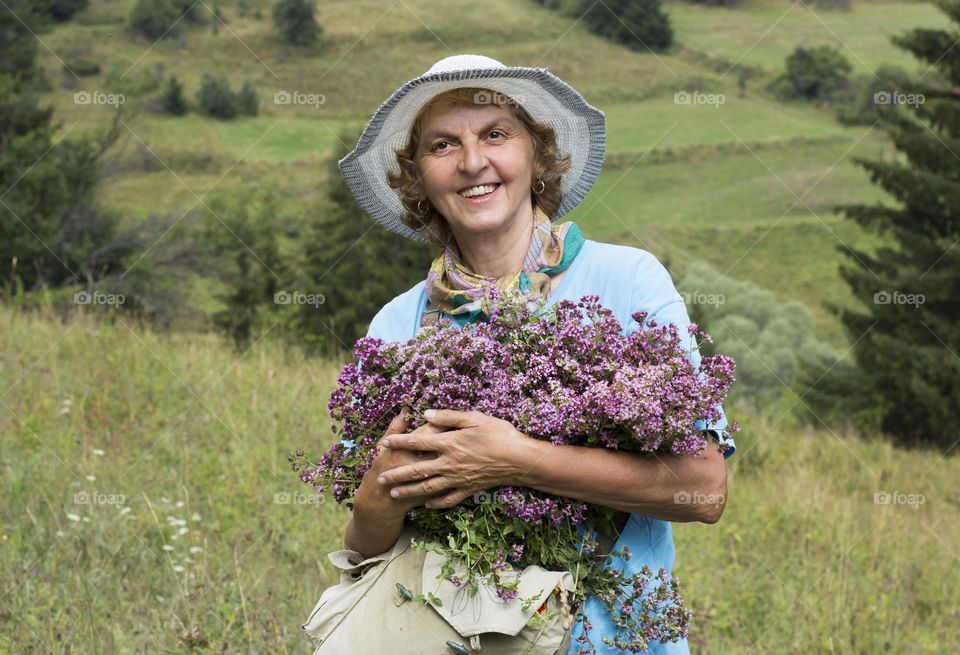 My mother holds oregano herbs and smiling