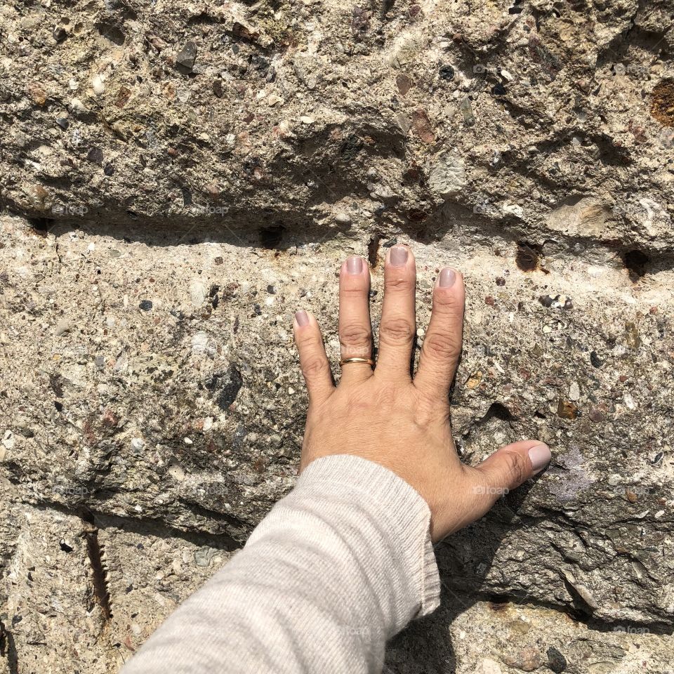 A woman hand touching Berlin Wall