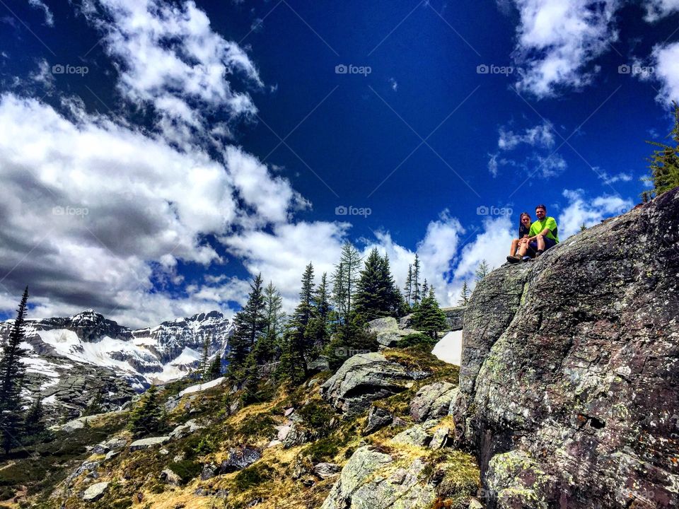 Beautiful couple sitting on mountain