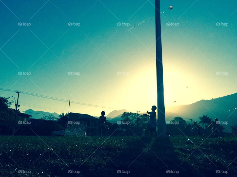 Kites and silhouettes . A boy plays with his Kite in Paraty. 