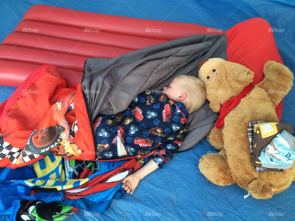 Elevated view of a boy sleeping with soft toy