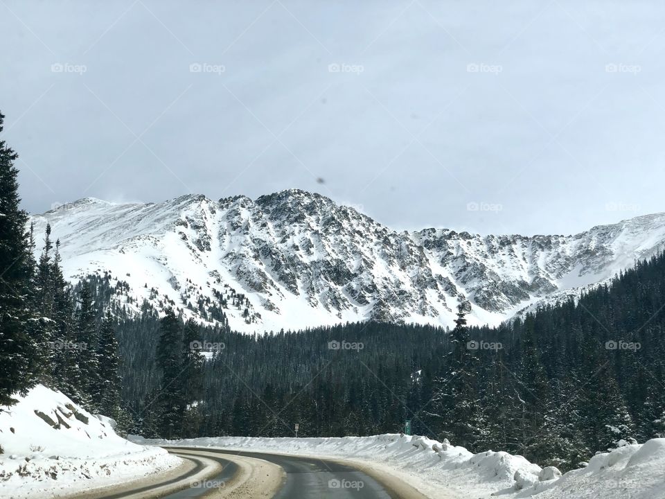 A drive through the mountain pass in autumn with snow.