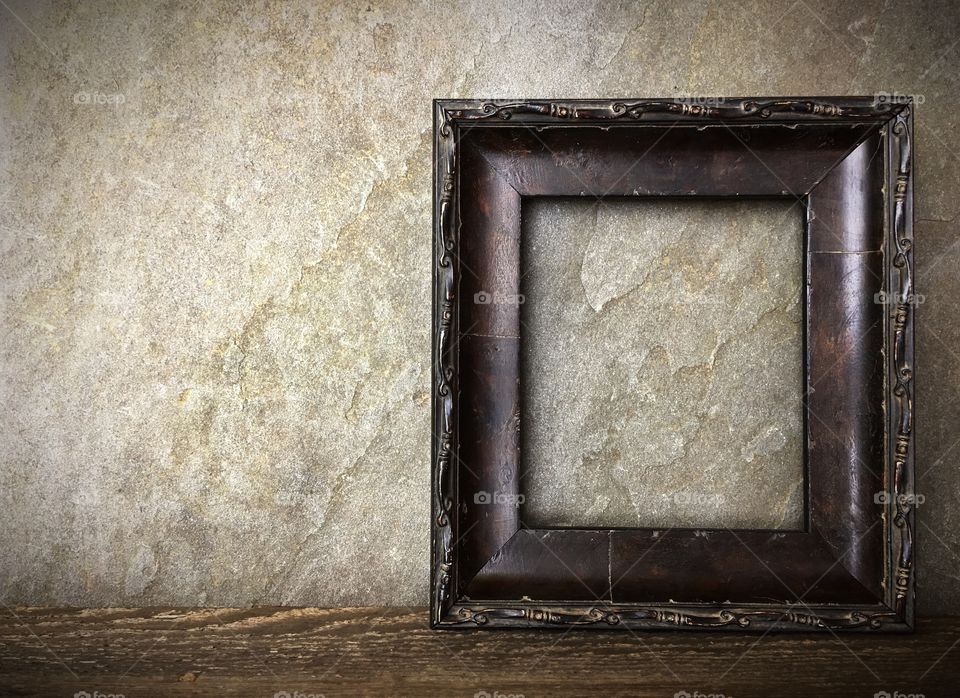 Dark wood picture frame against marble wall