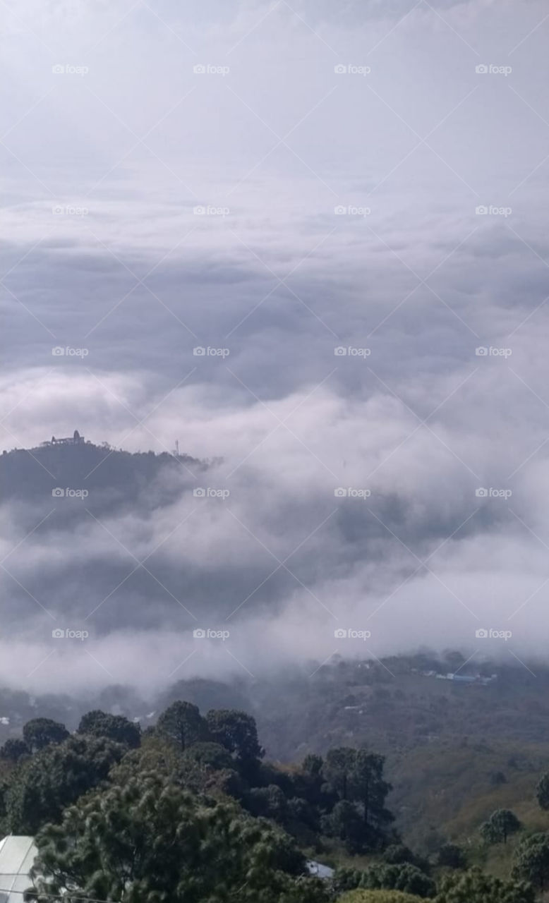 I captured this from top. this is the view of mountains and clouds are visible in this veiw at bottom