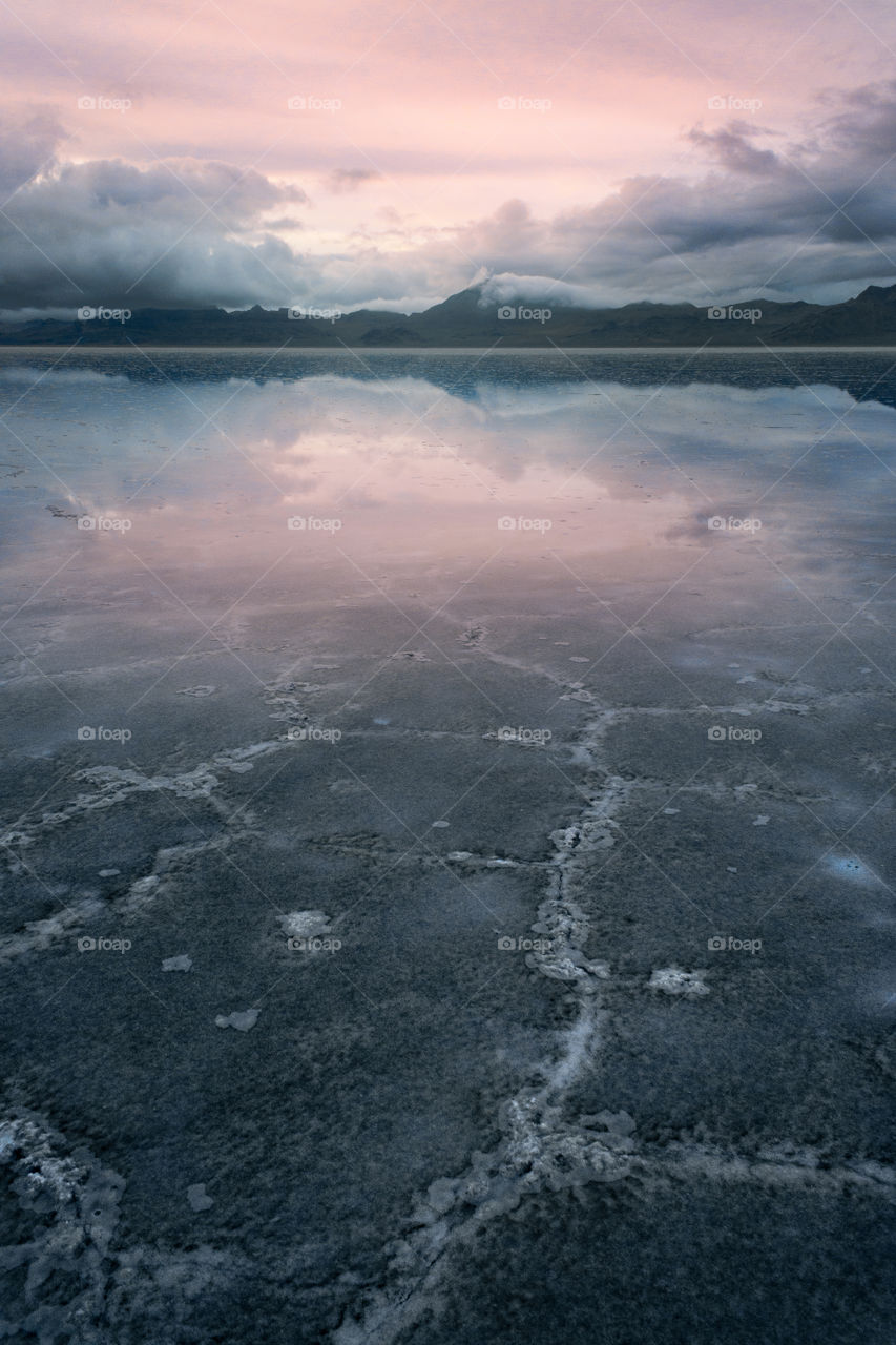 The sun sets on the Bonneville Salt Flats creating a colorful reflection.