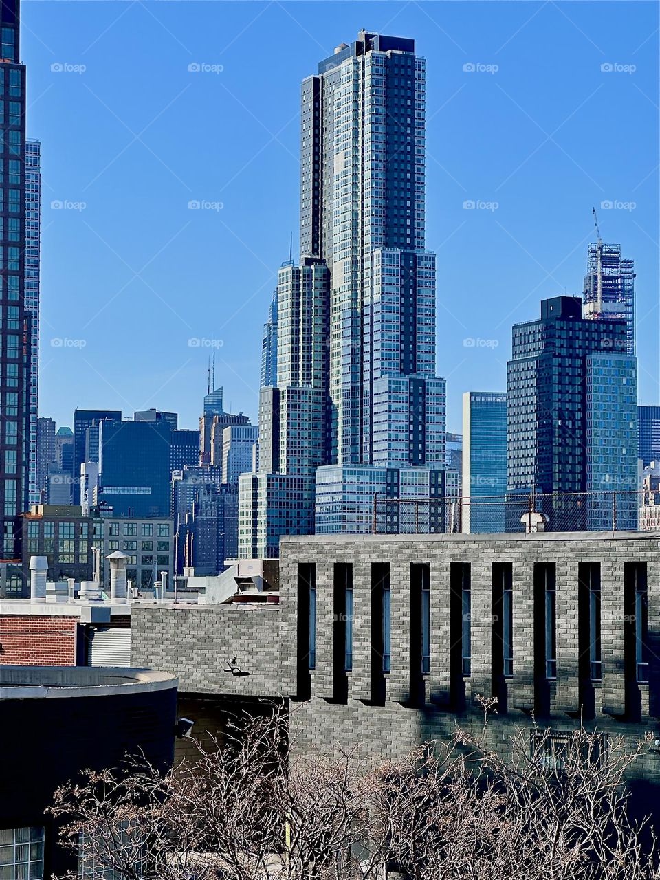 This is the view from the red metal staircase of the “Pulaski Bridge” at “Newtown Creek” on a sunny afternoon in late December 2023. We see “Greenpoint”, Brooklyn and in the furthest distance parts of “Manhattan”. Hypnotic Productions
