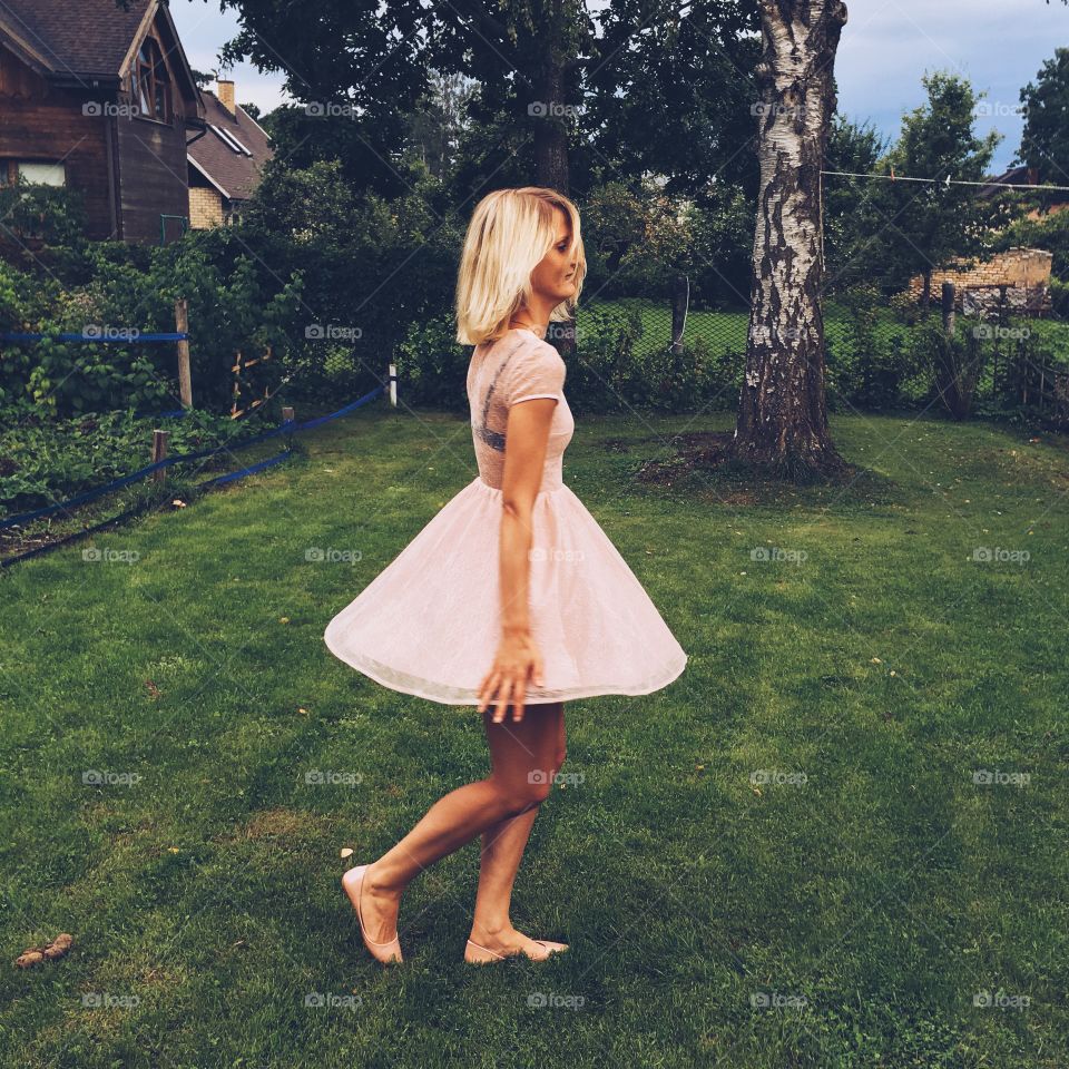 Blonde pretty woman walking on lawn