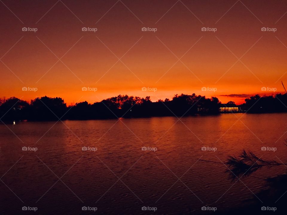 Orange Sky at Night FOAP delight. Lake waters smooth and reflections of backlit Conditions mirrored on Landscape. 