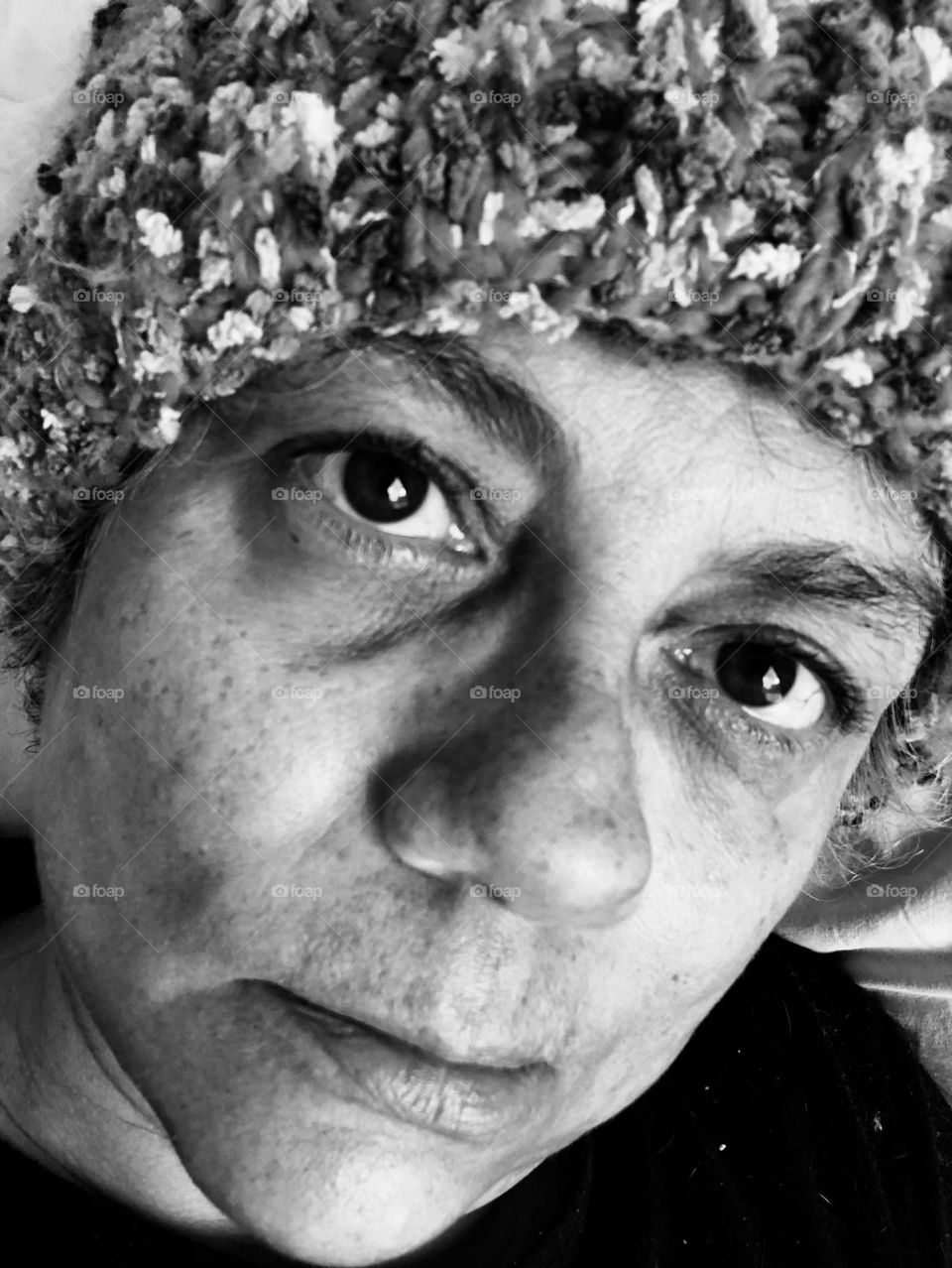 Woman in a wool hat shows her emotions for being stuck indoors during a particular cold winter weekend. 