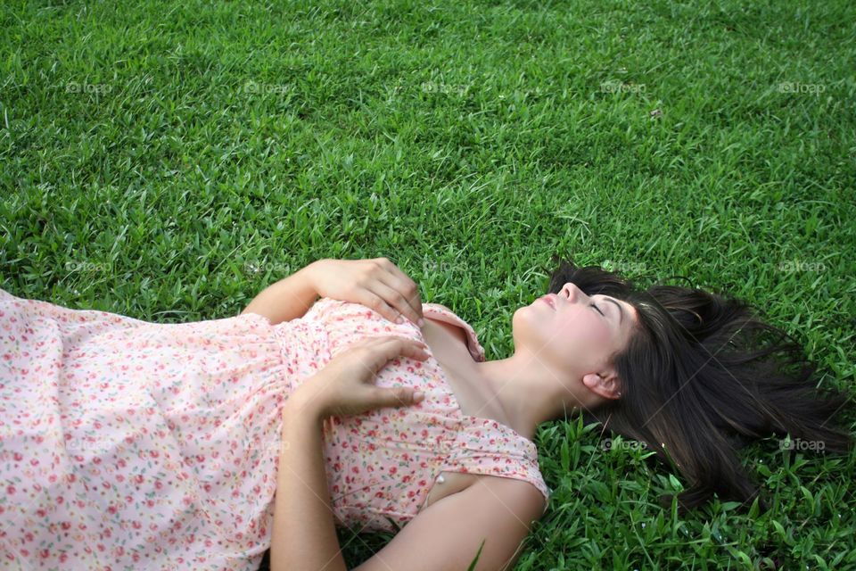 Beautiful woman lying on green grass