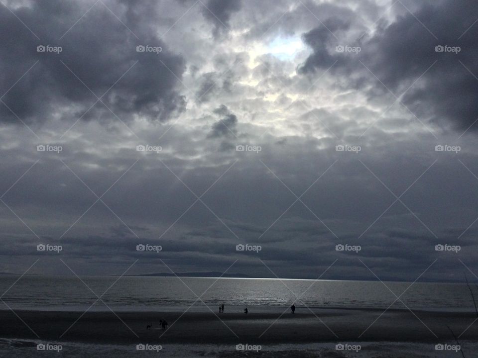 Sun trying to peak through the dark clouds over the ocean 