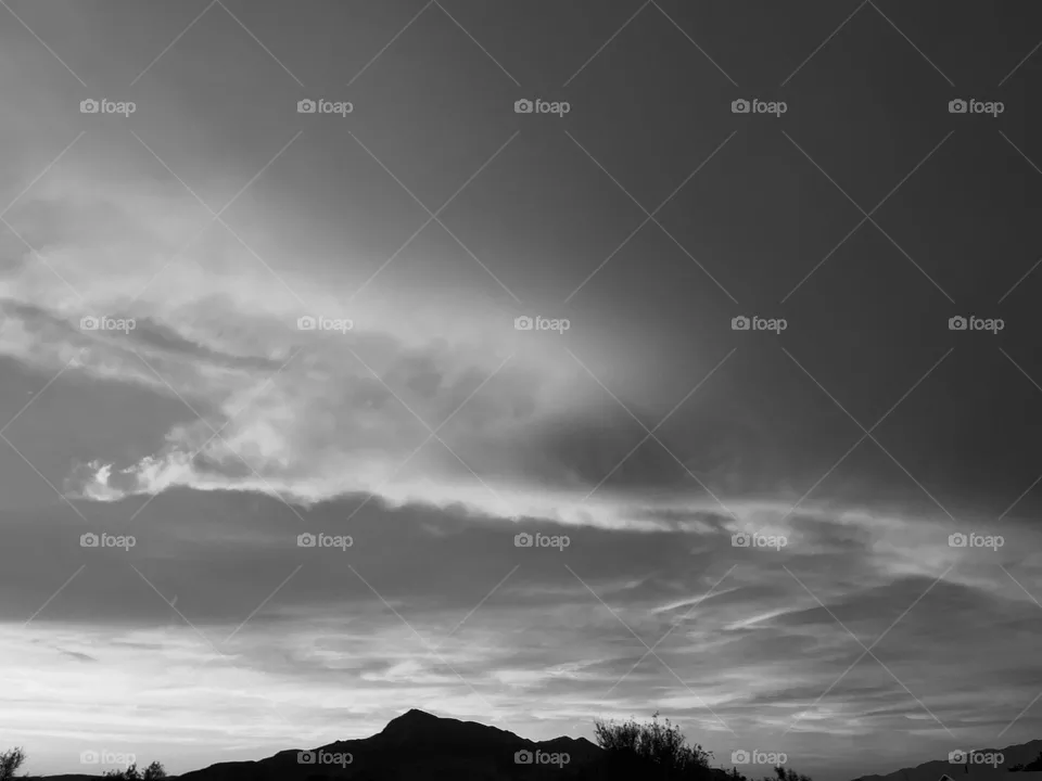 A black and white photo of mountains and clouds.  