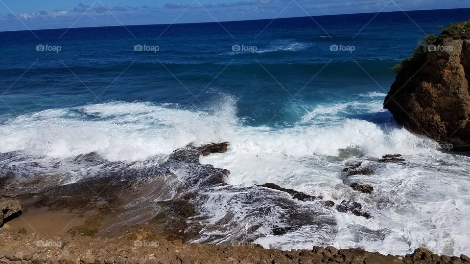 beautiful and powerful turquoise waves crash against the rocky coast in Puerto Rico.