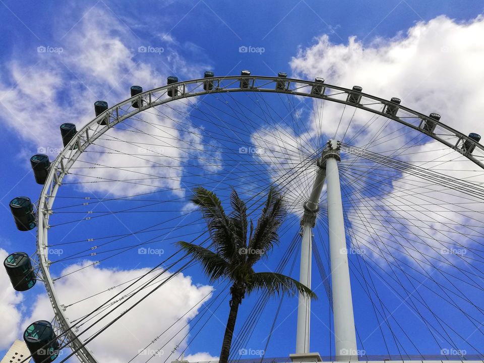 detail of ferris wheel between the blue sky and the clouds in Singapore