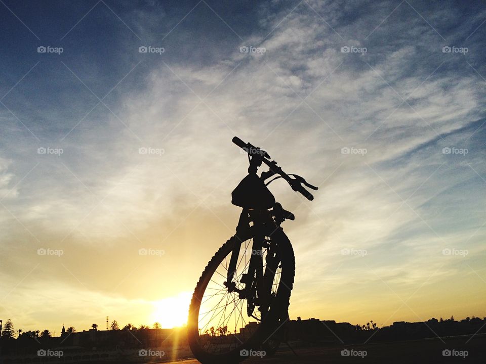 sunset behind a bycicle . yellow sunset behind a bycicle 