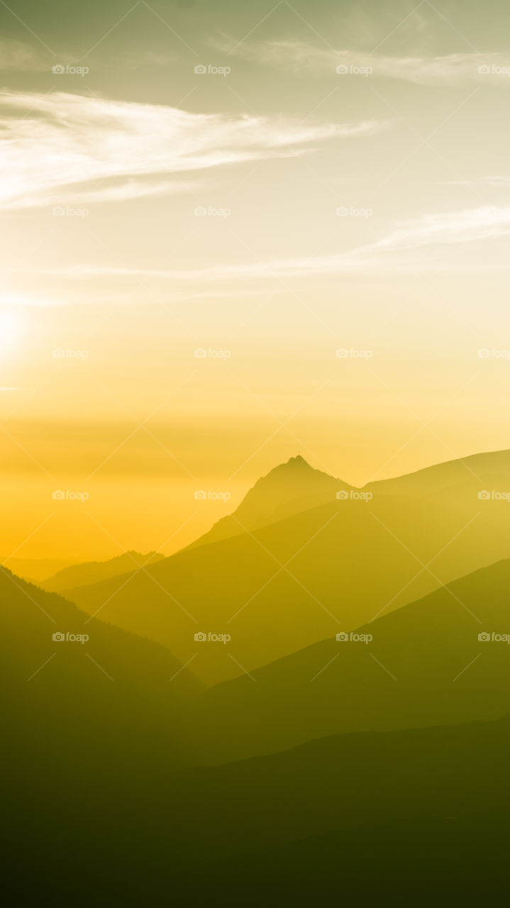 An inspiring mountain landscape. Tatry mountains in Slovakia. A beautiful wallpaper for smartphone screen. Warm summer haze, abstract gradient with perspective.