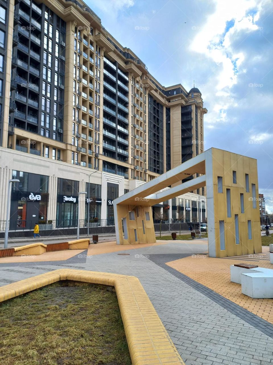 architectural building with shops and a beautiful park