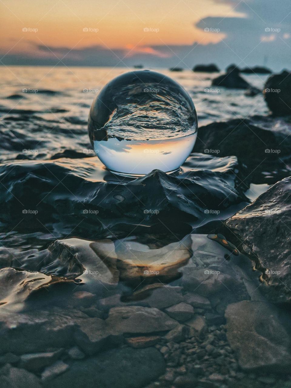 Top view of lensball,  crystal ball at the Adriatic seaside against sunset sky close up