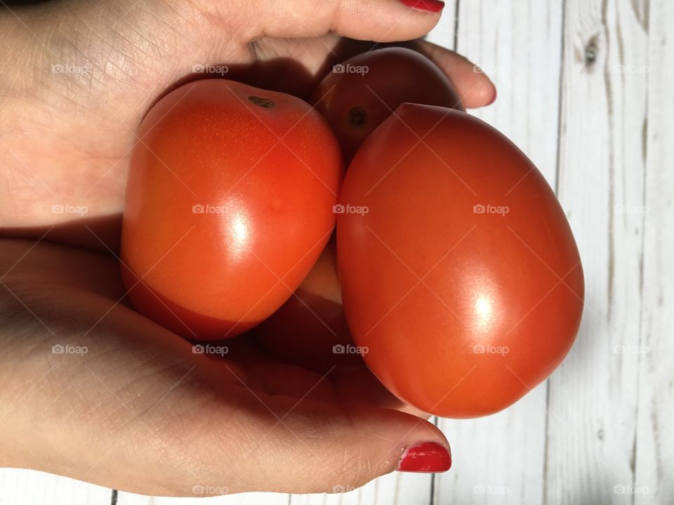 Hands holding tomatoes 