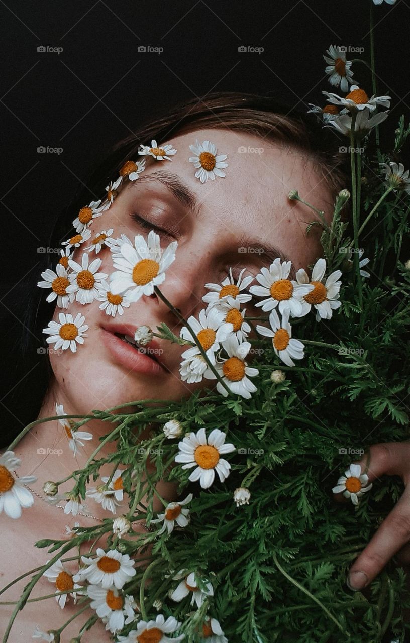 Portrait of a girl with a bouquet of field daisies