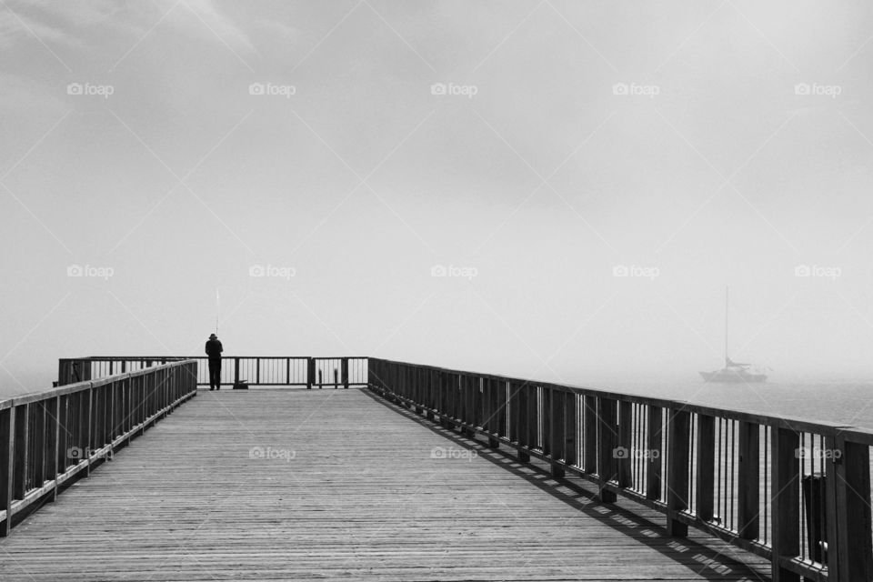 A fisherman standing on the pier