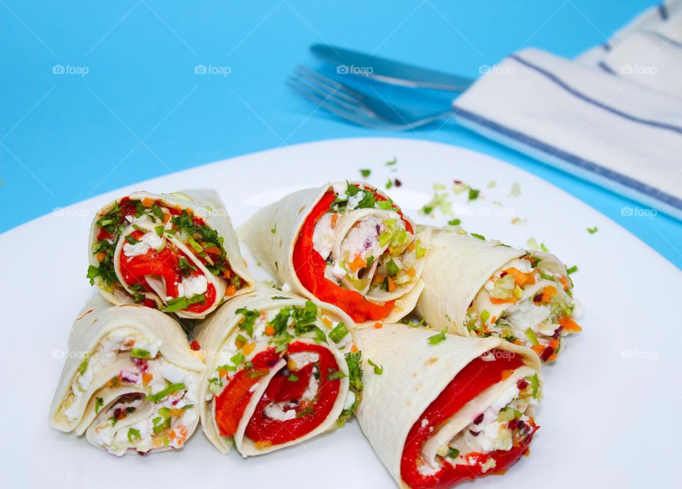 Tortilla with cheese and vegetables on a white plate. Vegetarian food