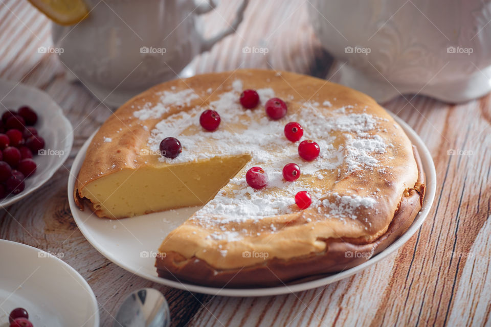 Cheesecake with cranberries and sugar on wooden background 