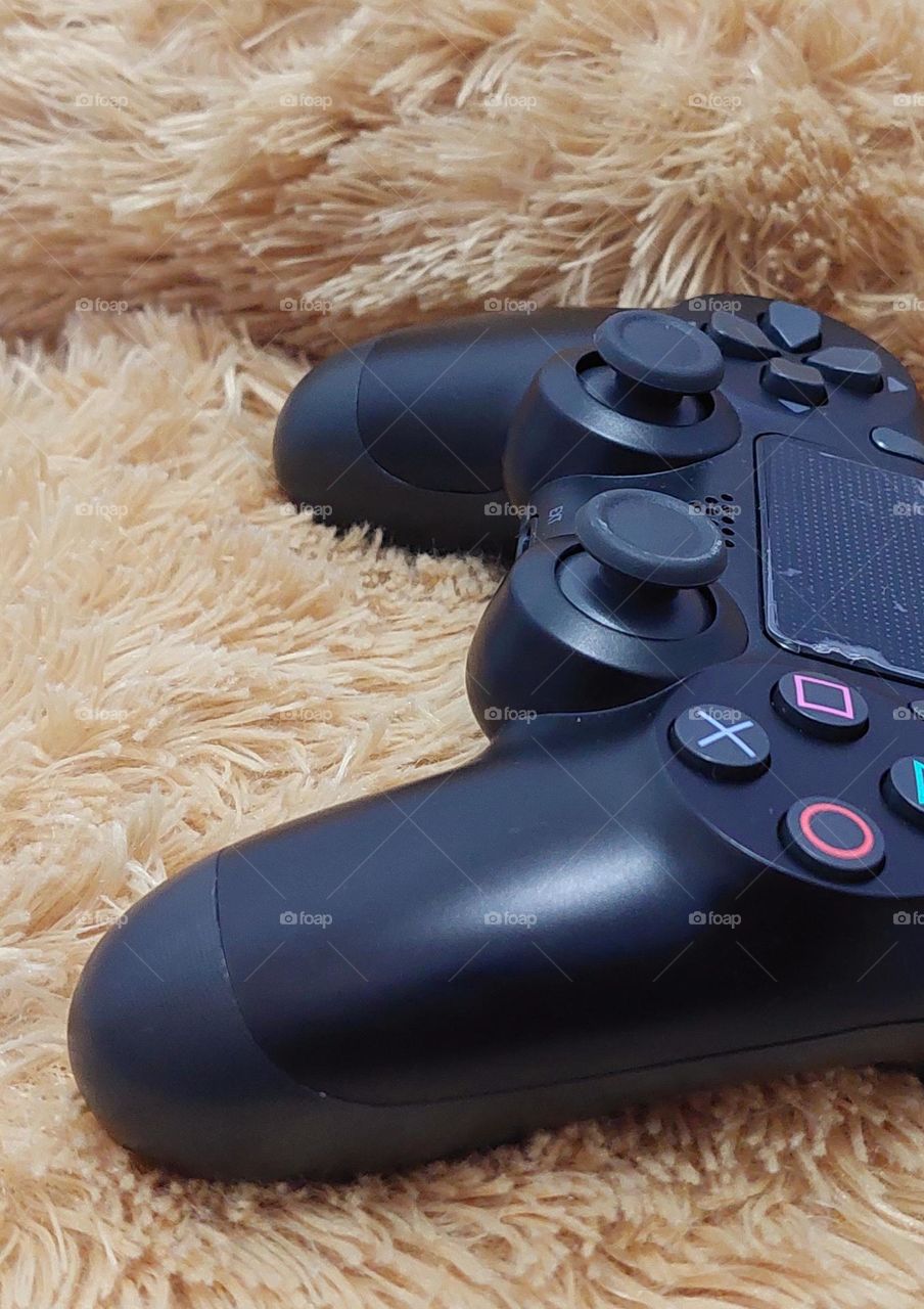 Close up black joystick gamepad against on brown background