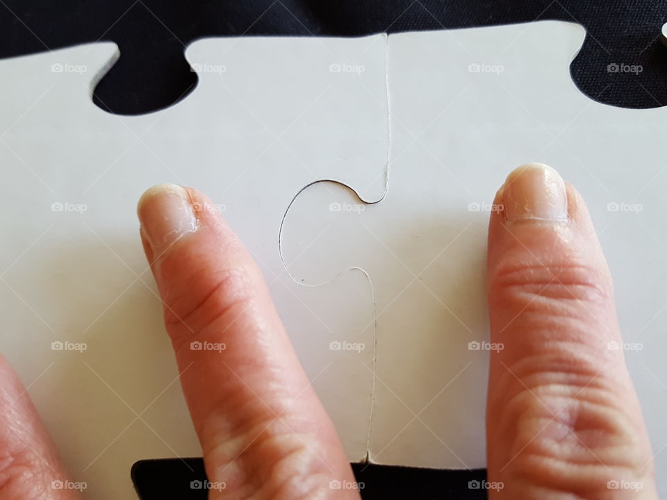 Close-up of human finger with puzzle pieces