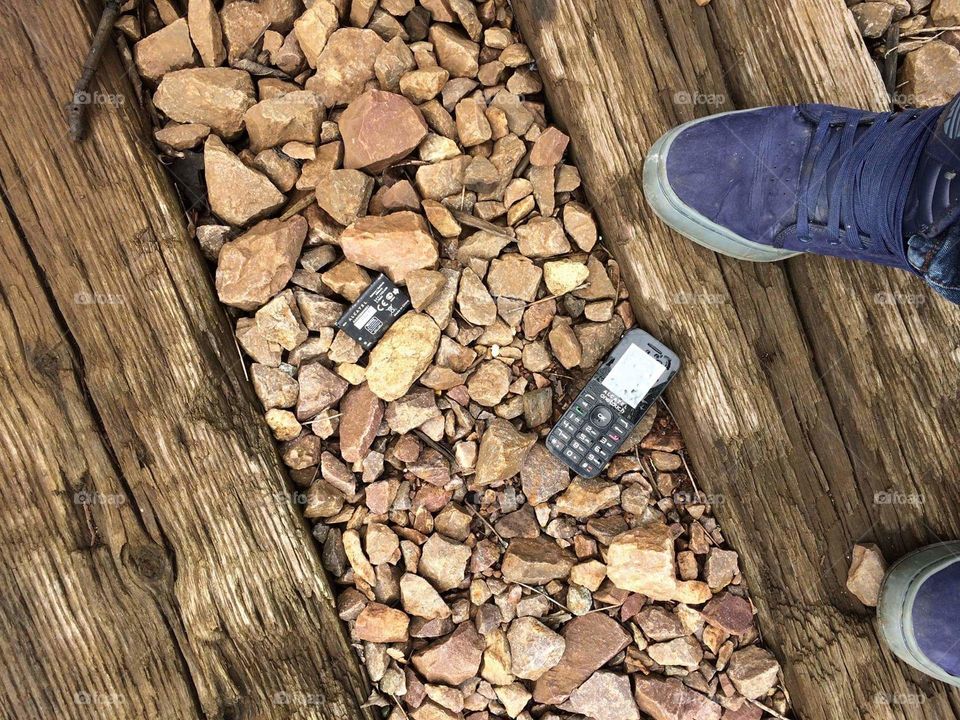 random phone and battery during urban trek, looking at railroad track