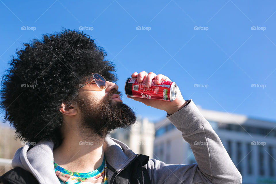 Guy drink tasty Coca-Cola, amazing day, spring mood 