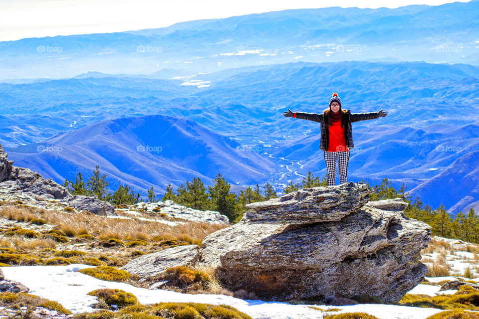 Woman with open arms at snowy mountains in Almeria, Spain