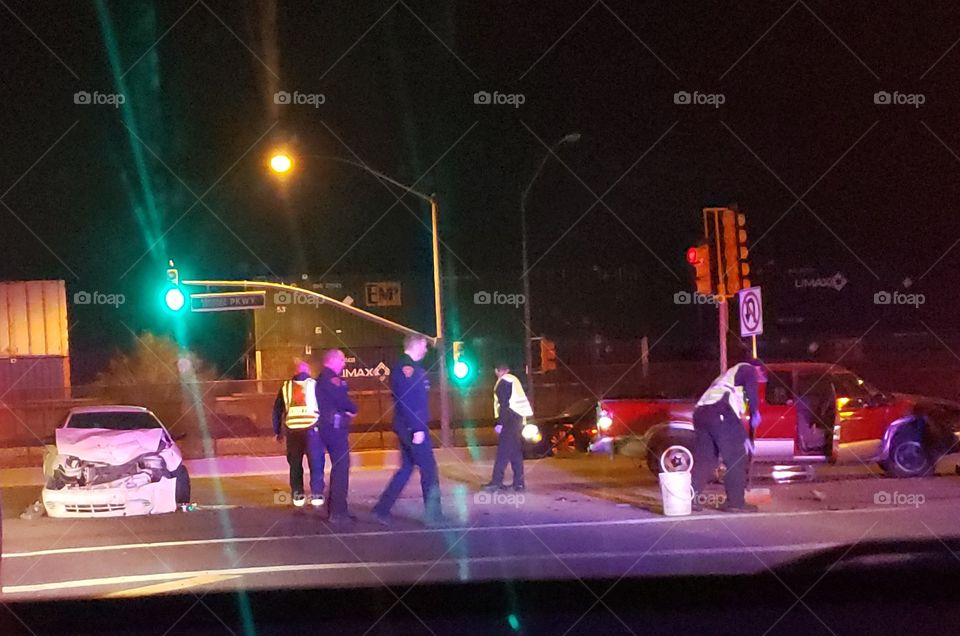 firemen and police cleaning up at an automobile accident scene