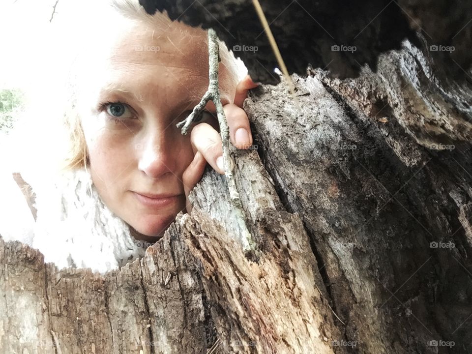 Woman looking through a tree