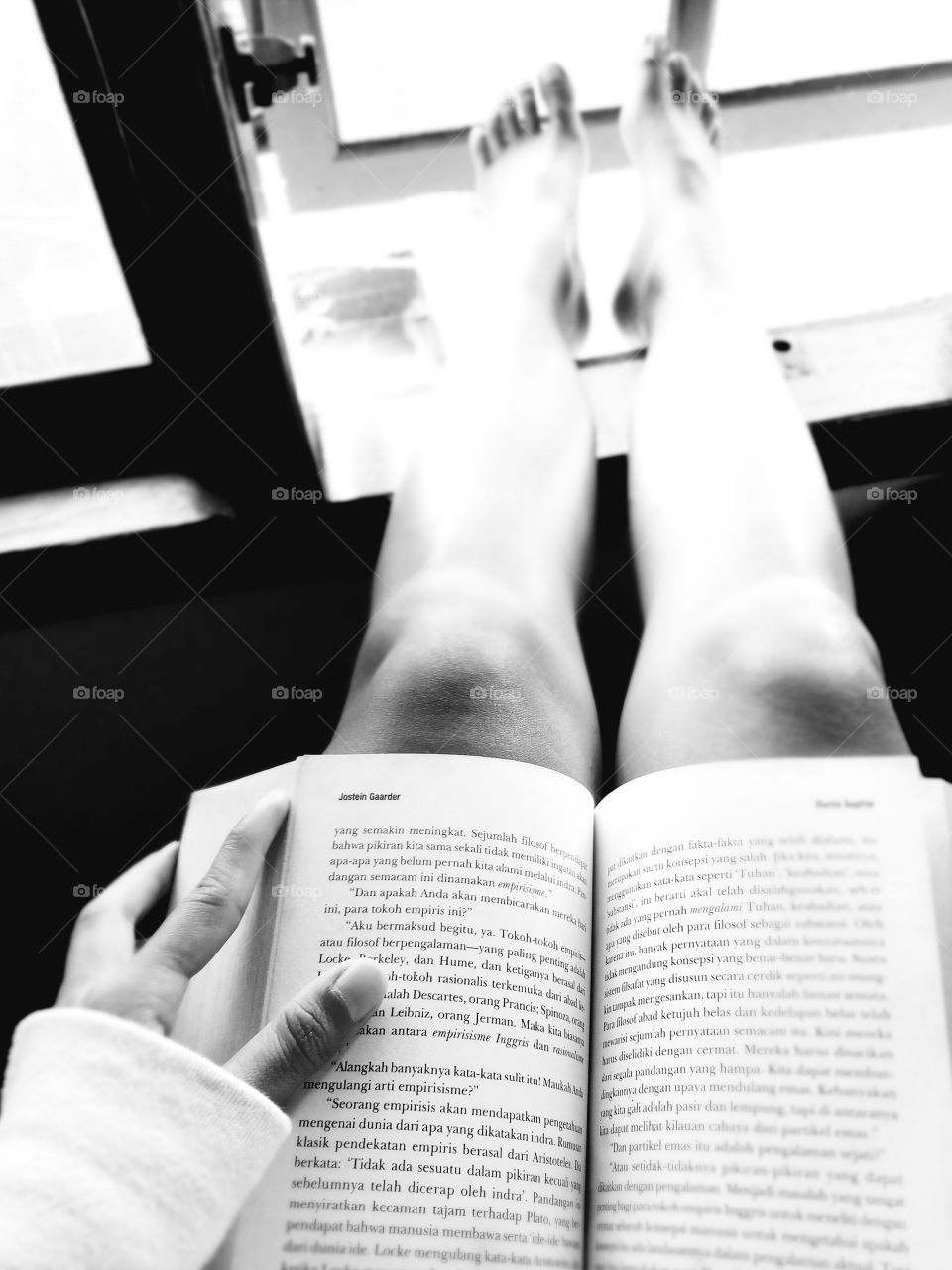 Reading a book in front of window.