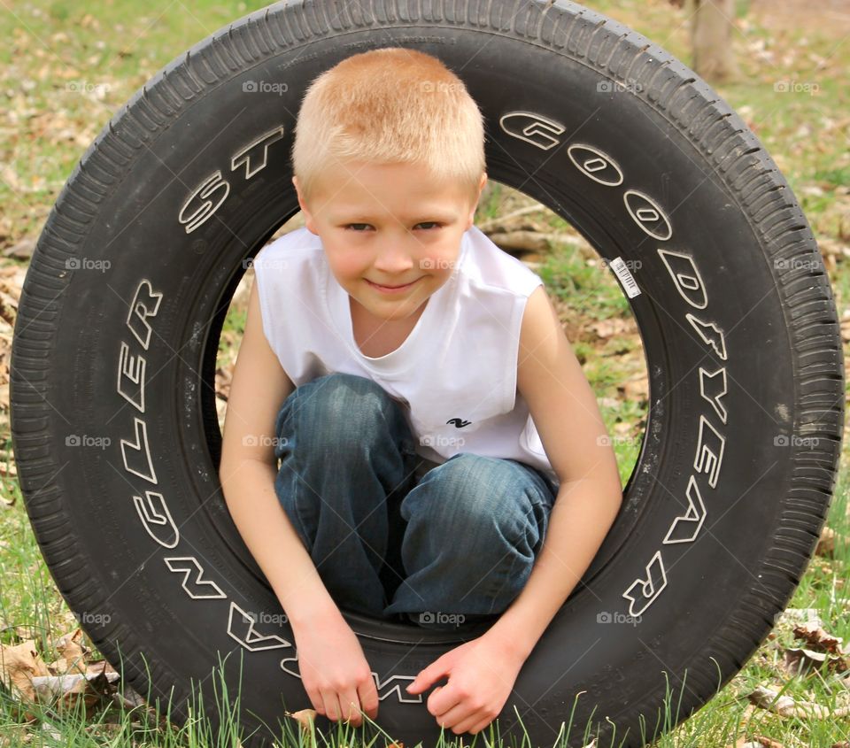 Portrait of a smiling boy in a tire