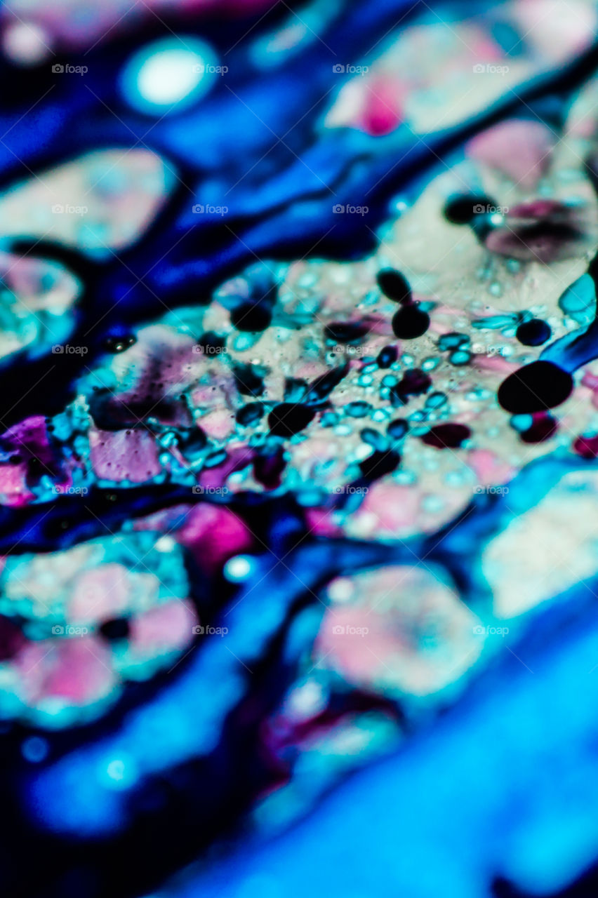 The ink to refill the printer cartridge was spilled onto the white washbasin and the paints blended into abstract drips and patterns.