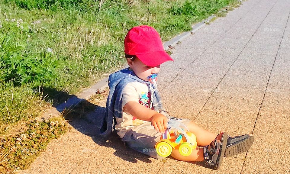 Little boy playing on pavement