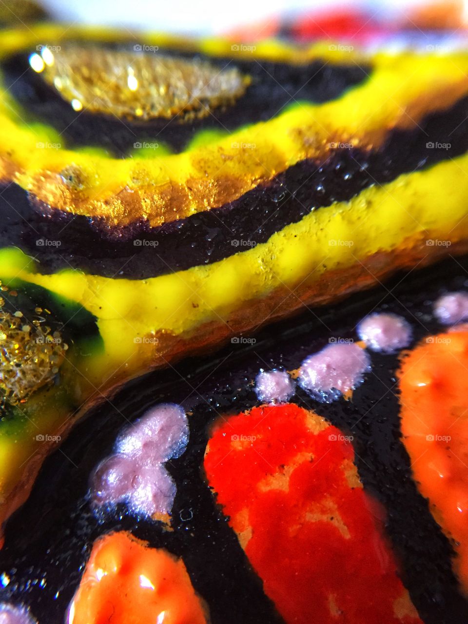 Close-up macro painted ceramic craft with vibrant colours