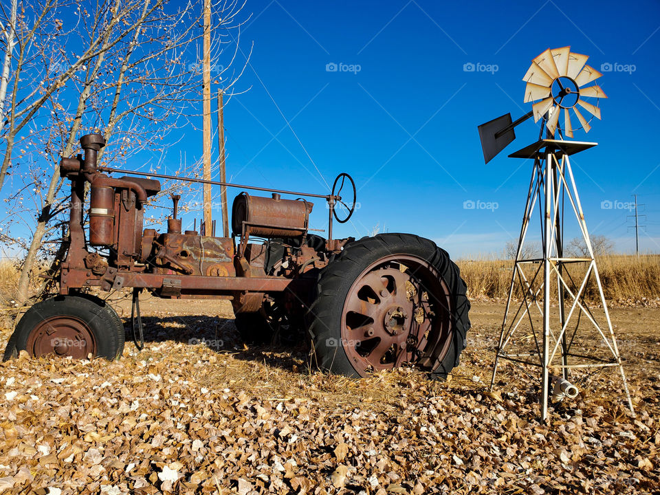 A old Case tractor rusts and disintegrates in a Colorado field after enduring many years of weather