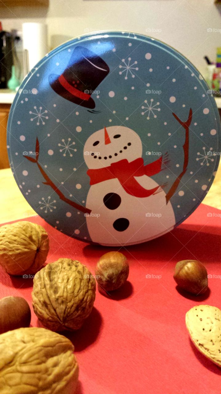 mixed nuts with snowman tin in background