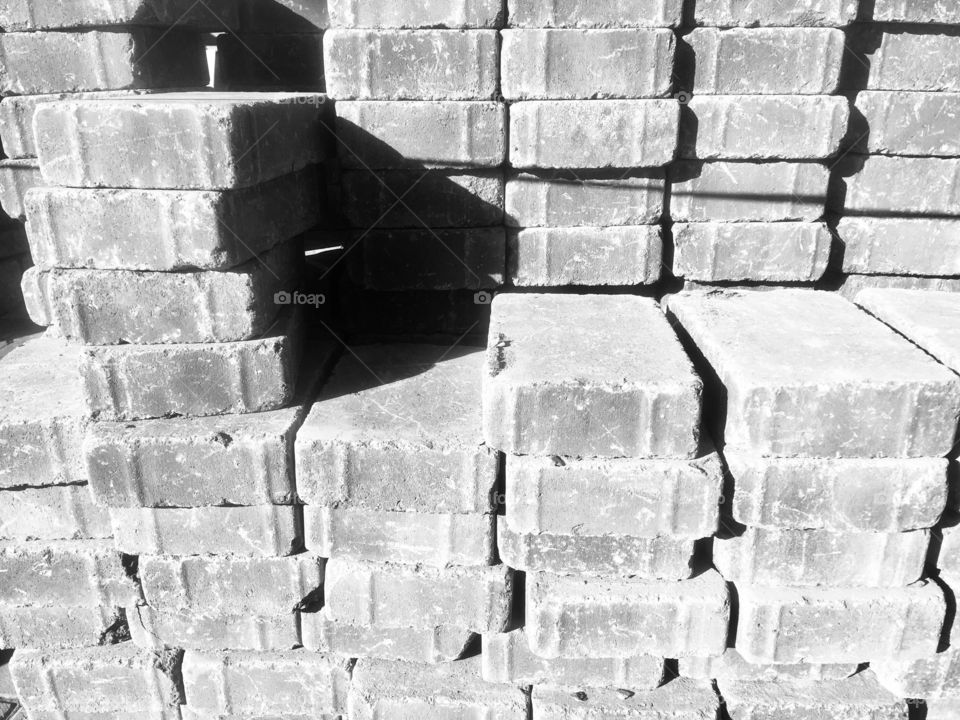 Grey bricks stacked outside residential property on Mill Way, Mill Hill, London, for building works
