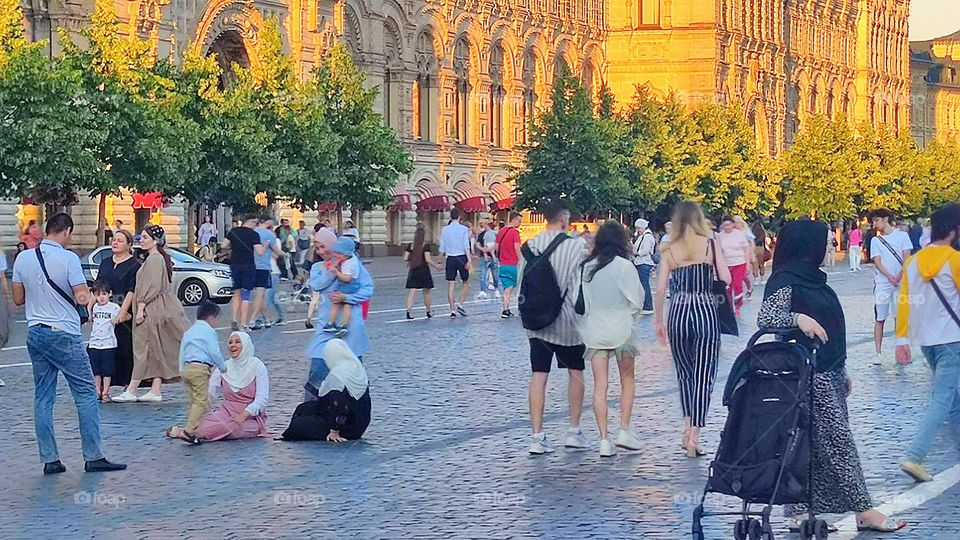 Summer. A huge number of tourists on Red Square from different countries. Smiling women an Arab country are sitting on the bruschatka square