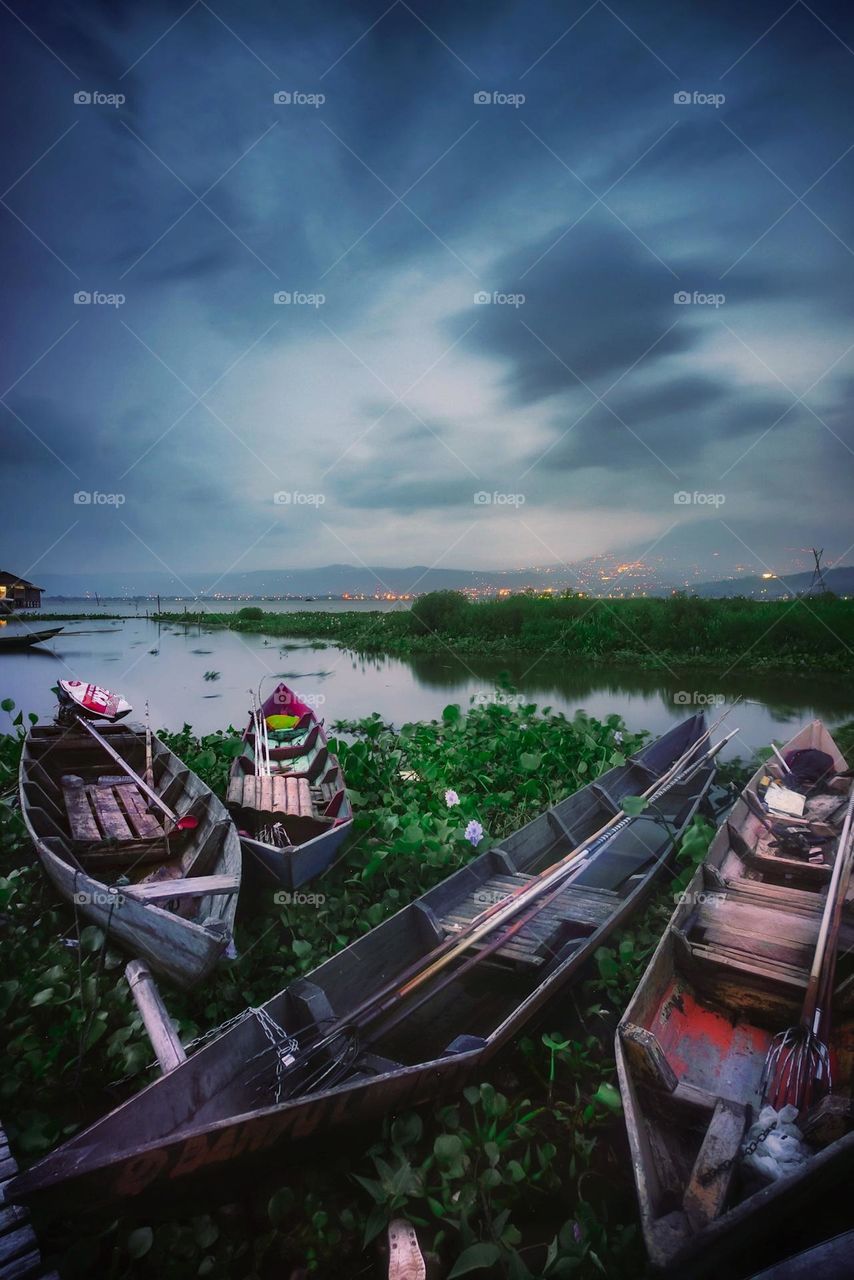 fishing boat leaning on the edge of the lake