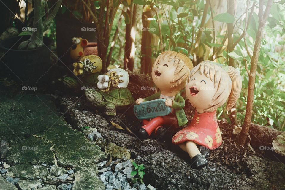Cute boy and girl smiling statue in the backyard